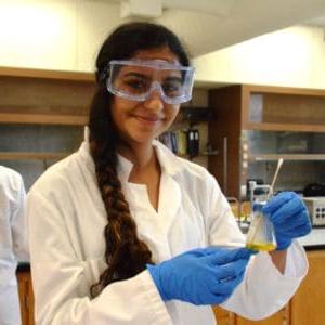 female student conducting experiment in chemistry lab