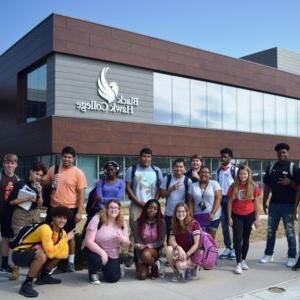 students pose in front of the Building 1 addition